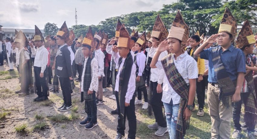 Peserta Upacara Peringatan Hardiknas di SMP Negeri 1 Raya Memakai Pakaian Adat Simalungun