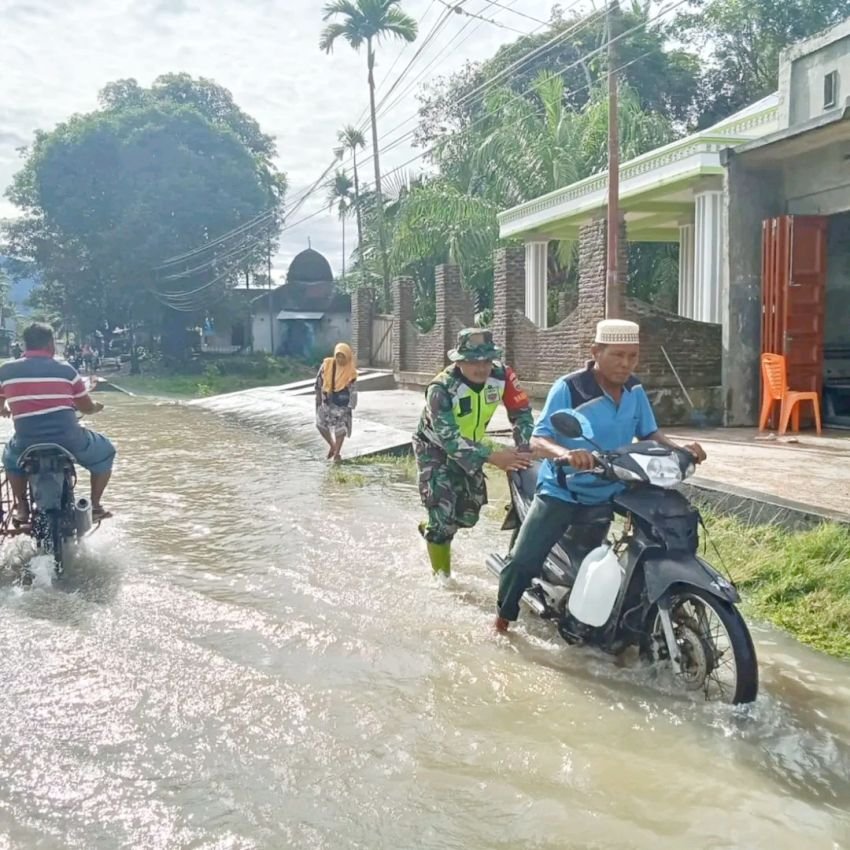 Babinsa Bantu Warga Melintasi Banjir di Barus