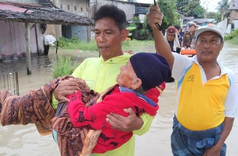 Babinkamtibmas Gendong Lansia Terobos Banjir di Sei Rampah